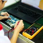 Eine Person führt einen Funktionstest an einer Platine aus